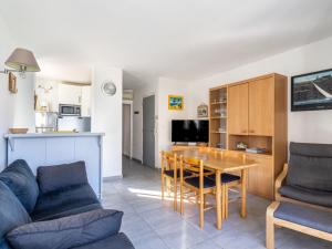 uma sala de estar com um sofá e uma mesa em Apartment L'Estelan-1 by Interhome em Le Lavandou