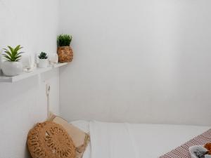 - une chambre avec des murs blancs et un lit orné de plantes dans l'établissement Apartment Les Flamants Roses-1 by Interhome, à La Grande Motte