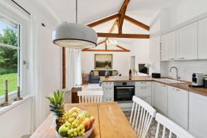 Una cocina con una mesa con un bol de fruta encima. en Idylisches Cottage mit Reh, en Wörthsee 32 fotos más