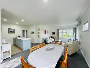 a dining room and living room with a table and chairs at Stay on Glanmire in Wellington