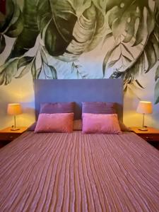 um quarto com uma cama com um quadro na parede em Villa Centaurea Apartment with private parking em Taormina