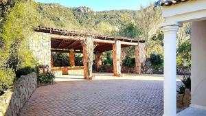 a building with a pavilion with mountains in the background at Villa Elisa, un paradis à Figari in Figari