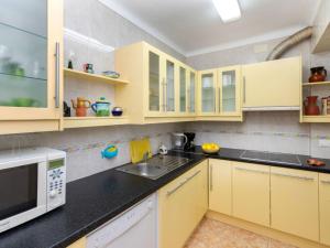 a kitchen with yellow cabinets and a microwave at Apartment Les Oranetes by Interhome in Llança