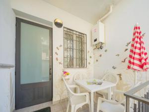 una sala da pranzo con tavolo, sedie e porta di Apartment La casa della ceramista by Interhome a Viareggio