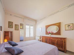 una camera da letto con un letto e uno specchio a parete di Apartment La casa della ceramista by Interhome a Viareggio