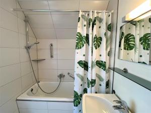ein Badezimmer mit einem Duschvorhang, einem Waschbecken und einer Badewanne in der Unterkunft Apartment Wichtelmännchen by Interhome in Dittishausen
