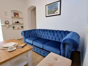 a blue couch in a living room with a table at Apartment Antoine by Interhome in Marina