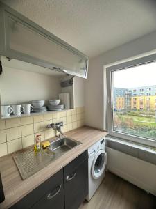 cocina con fregadero y lavadora en Zentrale 200m entfernt von HBF Bis 6 Gäste mit 3 zimmer 80m2, en Essen