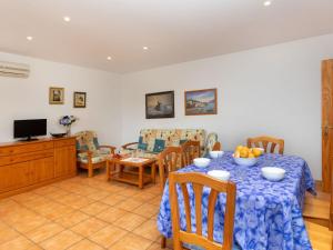 comedor con mesa, sillas y TV en Apartment Barlovento by Interhome, en Llançà