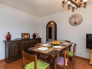 comedor con mesa, sillas y reloj en Apartment Sarnella by Interhome, en Llançà
