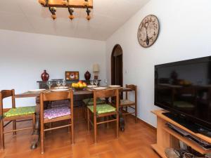 comedor con mesa y reloj en la pared en Apartment Sarnella by Interhome, en Llançà