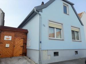 a white house with a wooden door and windows at Appartement blue Dinghi in Mörbisch am See