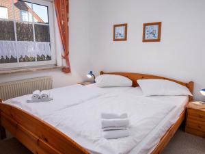 ein Schlafzimmer mit einem Bett mit weißen Handtüchern darauf in der Unterkunft Apartment Küstennebel by Interhome in Norddeich