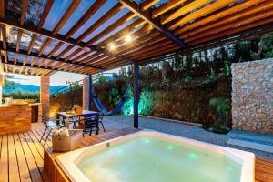 an outdoor pool with a hot tub on a deck at Sweet Helen Llanogarden in Rionegro