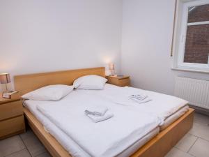 ノルトダイヒにあるApartment Windlicht by Interhomeのベッドルーム1室(大きな白いベッド1台、スリッパ2枚付)