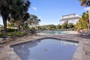 una gran piscina con sillas y un edificio en Mer Sea by AvantStay Ocean View w Community Pool Access, en Isle of Palms