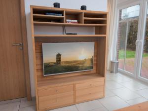 ノルトダイヒにあるApartment Windlicht by Interhomeの木製エンターテイメントセンターの薄型テレビ