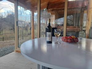- une bouteille de vin et un bol de pommes sur une table dans l'établissement Apartman Tošić, à Trnava