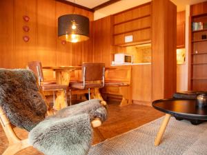ein Wohnzimmer mit einem Tisch und einem Stuhl in der Unterkunft Apartment Opale 4 by Interhome in Villars-sur-Ollon