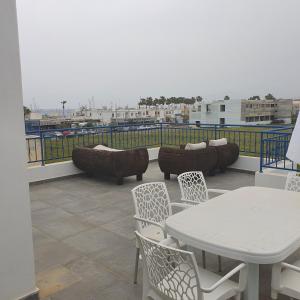 a patio with a table and chairs on a balcony at G&E Harbour Apartments in Lachi
