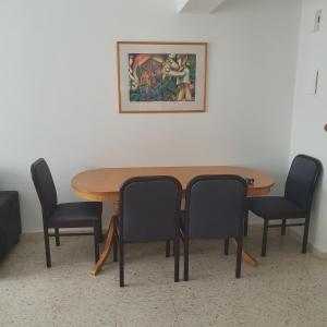 a wooden table with chairs and a picture on the wall at G&E Harbour Apartments in Lachi