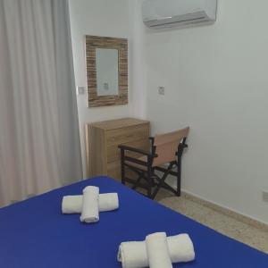 a bedroom with a blue bed with two rolled towels at G&E Harbour Apartments in Lachi