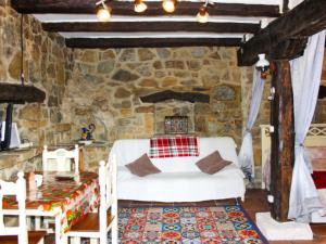 1 dormitorio con cama blanca y pared de piedra en Apartment Potes Vinon - Cabaña by Interhome, en Tama