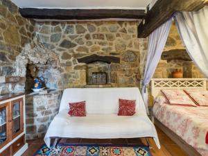 1 dormitorio con cama y pared de piedra en Apartment Potes Vinon - Cabaña by Interhome, en Tama