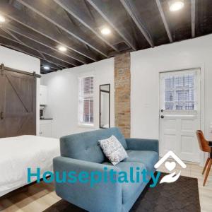 a bedroom with a blue couch and a bed at Housepitality - The Reichstag Suite - Modern in Columbus