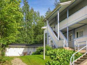 a building with a staircase next to a yard at Holiday Home Hiukanhelmi by Interhome in Sotkamo