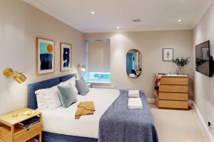 a bedroom with a large white bed with a blue blanket at Madison Hill - White Hill House 3 - 1 bedroom flat in London