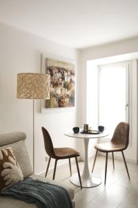 a living room with a table and chairs at URBAN HOME in Bari +29 photos
