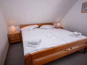 Schlafzimmer mit einem Bett mit weißer Bettwäsche und Handtüchern in der Unterkunft Apartment Poseidon by Interhome in Norddeich