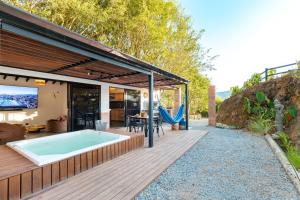 a house with a hot tub on a wooden deck at Sweet Helen Llanogarden in Rionegro