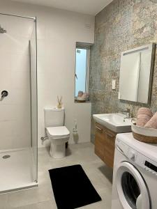 bagno con lavandino e servizi igienici e lavatrice. di Spacious and Cozy Apartment near St Julians - Short Let Apartments Malta a Is-Swieqi