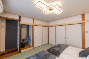1 dormitorio con 1 cama y ventilador de techo en It' ta de JPN - Self Check-In Only, en Osaka