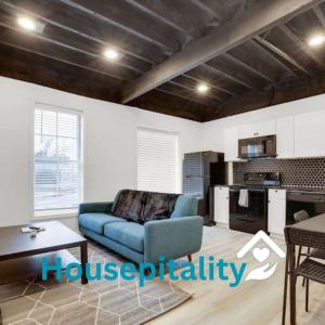 sala de estar con sofá azul y cocina en Housepitality - The Neuschwanstein Flat, en Columbus