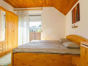 a bedroom with a wooden bed with a window at Holiday Home Aurora by Interhome in Zamárdi