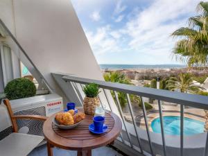 a table with a bowl of food on a balcony at Apartment La Calypso-5 by Interhome in La Grande-Motte