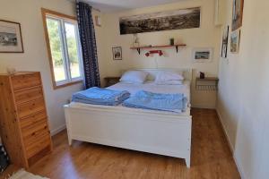 um quarto com uma cama branca e lençóis azuis em Fantastiskt hus på fårö em Fårö