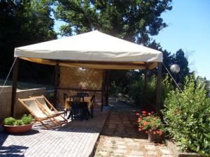 a white tent with a table and chairs under it at Apartment Stregaia-4 by Interhome in Montaperti