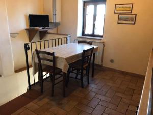 mesa y sillas en una habitación con TV en Apartment Stregaia-5 by Interhome, en Montaperti