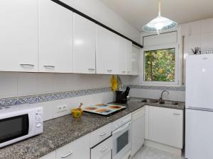 a kitchen with white cabinets and a white refrigerator at Holiday Home El Morer by Interhome in Llança