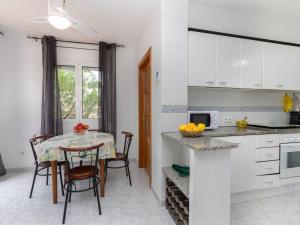 a kitchen with a table and a table and chairs at Holiday Home El Morer by Interhome in Llança
