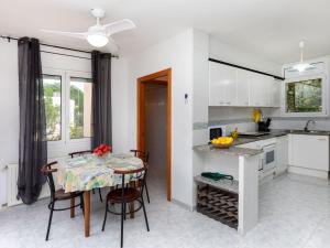 a kitchen with a table and chairs and a kitchen with white cabinets at Holiday Home El Morer by Interhome in Llança +16 photos