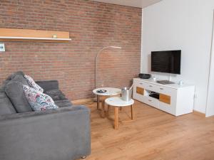 ein Wohnzimmer mit einem Sofa und einem TV in der Unterkunft Holiday Home Kotthaus by Interhome in Norddeich