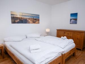 ein Schlafzimmer mit einem großen Bett mit weißer Bettwäsche in der Unterkunft Holiday Home Kotthaus by Interhome in Norddeich