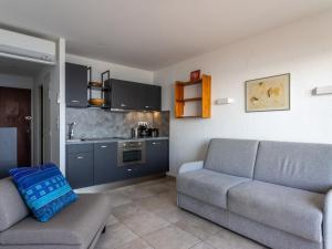 Il comprend un salon avec un canapé et une cuisine. dans l'établissement Studio Les Horizons by Interhome, au Lavandou