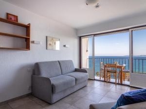 - un salon avec un canapé et une vue sur l'océan dans l'établissement Studio Les Horizons by Interhome, au Lavandou