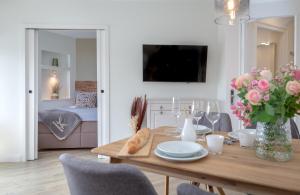 a dining room with a table with a vase of flowers at Louis in Westerland (Sylt)